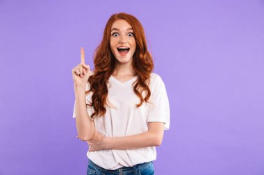 Kopya alanı işaret menekşe arka plan üzerinde izole bir neşeli genç kız ayakta portresi