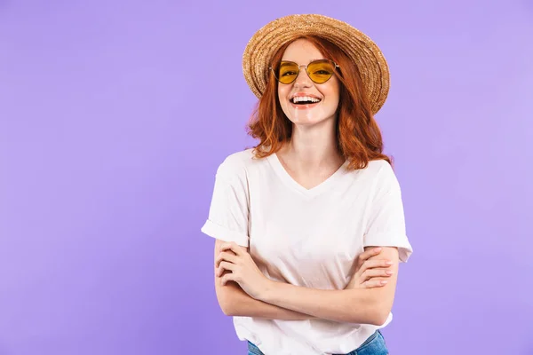 麦わら帽子とサングラスを紫色の背景に分離立っての陽気な若い女の子の肖像画 — ストック写真