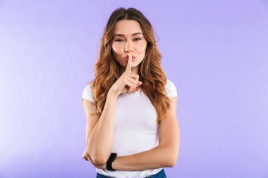 Sessizlik jest gösterilen mor duvar arka plan üzerinde izole kadın fotoğrafı.