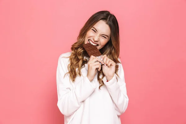 Portrait Happy Young Woman Biting Chocolate Bar Isolated Pink Background — Stock Photo, Image