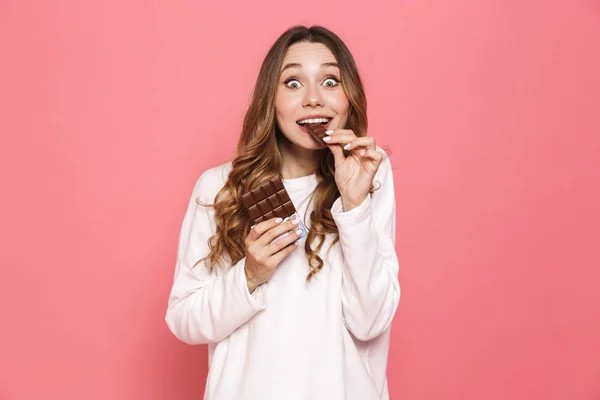 Portrait Happy Young Woman Eating Chocolate Bar Isolated Pink Background — Stock Photo, Image