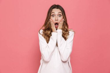 Şok bir genç casual kız çığlık pembe arka plan üzerinde izole portresi