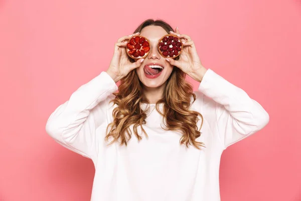 ピンク背景に分離した 彼女の顔で菓子を示す幸せな若い女の肖像 — ストック写真