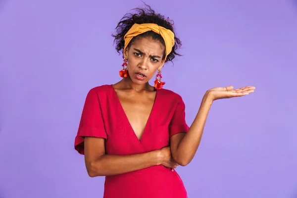鉢巻き立っている紫色の背景上にコピー スペースを提示に対応する混乱若いアフリカ女性の肖像 — ストック写真