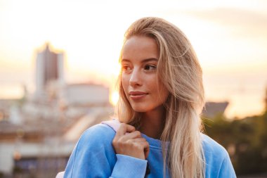 Sırt çantası ayakta açık havada günbatımı sırasında genç ve güzel bir kızla portresi