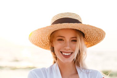 Görüntü güzel şirin sarışın kadının açık havada kamera seyir vasıl belgili tanımlık kıyı şapka.