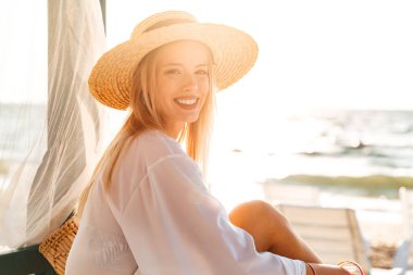 Mutlu genç kız yaz şapka ve güneşli kumsalda dinlenme mayo