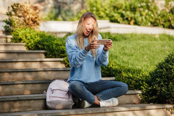 Portréja Egy Vidám Fiatal Lány Diák Hátizsák Játék Játékok Mobiltelefon — Stock Fotó