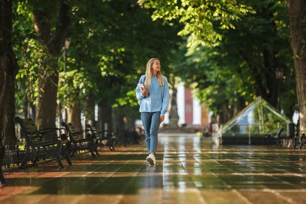 一个快乐的年轻女孩的肖像与背包和教科书在公园散步 — 图库照片
