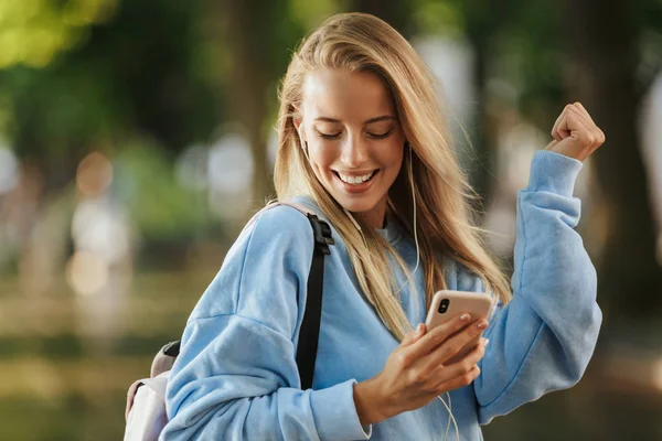 Весела Молода Студентка Рюкзаком Тримає Мобільний Телефон Ходить Парку Слухає — стокове фото