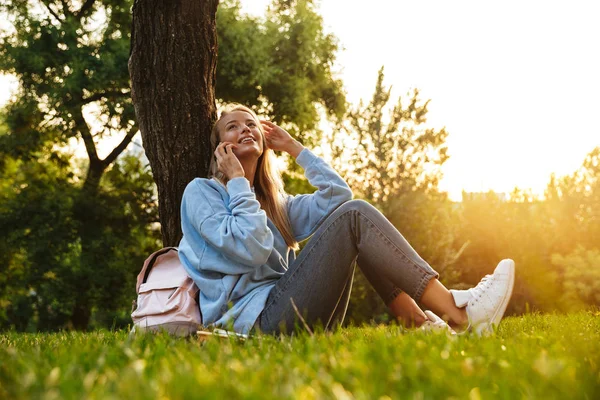 Cep Telefonu Üzerinde Konuşurken Bir Parkta Oturan Mutlu Genç Bir — Stok fotoğraf