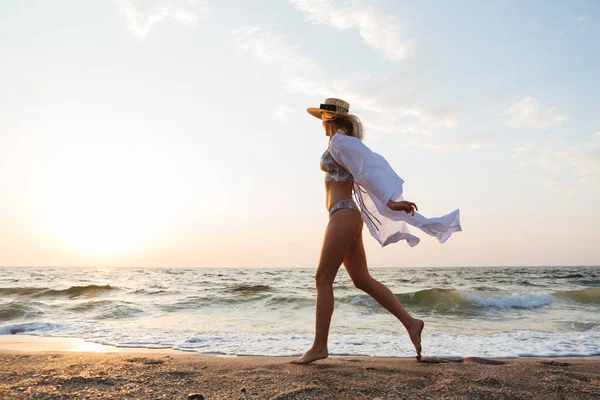 帽子がビーチで野外を歩いていると美しい若い金髪女性の画像 — ストック写真