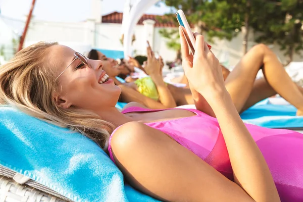 Lachende Jonge Vrouw Gekleed Badpak Mobiele Telefoon Houden Terwijl Ontspant — Stockfoto