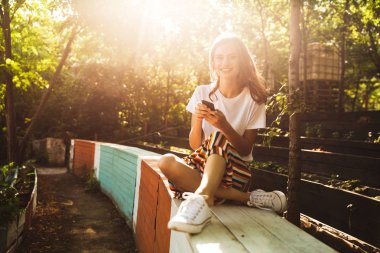 Hareket eden telefon vasıl belgili tanımlık park açık havada kullanan mutlu genç kız