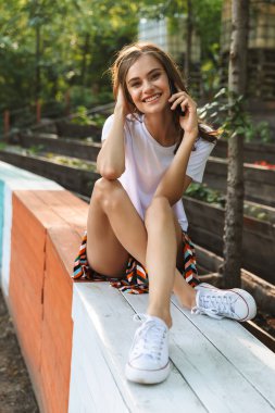 Hareket eden telefon vasıl belgili tanımlık park açık havada konuşurken neşeli genç kız