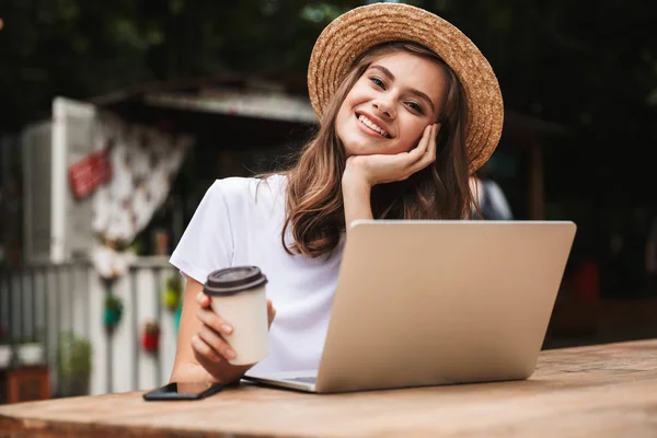 Hermosa Chica Joven Bebiendo Café Mientras Está Sentado Con Ordenador —  Fotos de Stock