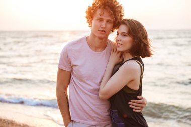 Hoş bir genç çift sahilde sarılma portresi
