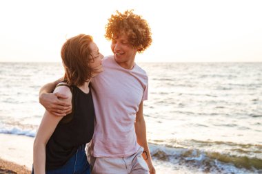 Sevimli genç mutlu sevgi dolu çift açık havada sahilde sarılma görüntü.