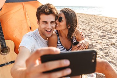 Selfie tarafından cep telefonu açık havada sahilde genç Sevimli sevgi dolu çift olun.
