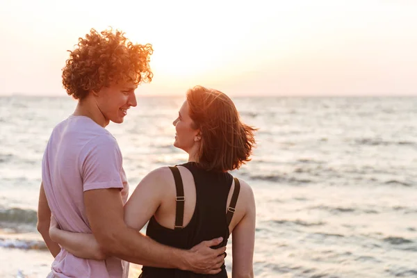 一对可爱的年轻夫妇的肖像拥抱在海滩上 看日出 — 图库照片