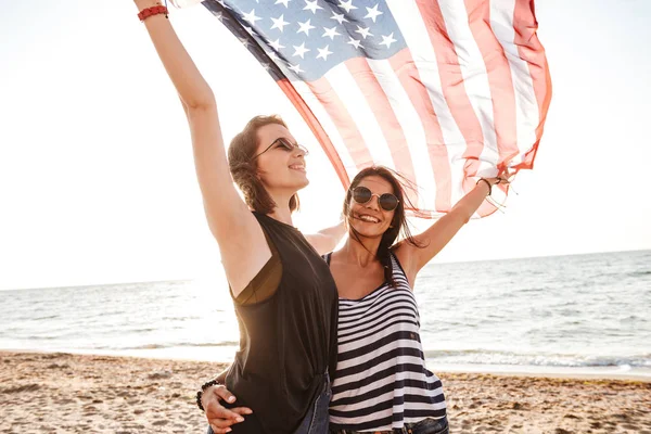 快乐兴奋的形象 在海滩上举行美国国旗有趣的女孩朋友户外 — 图库照片