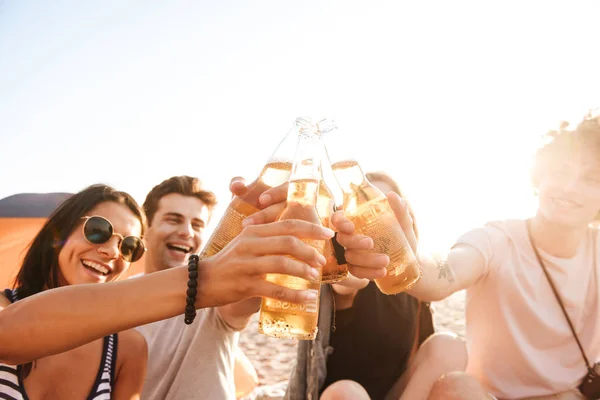ビールを飲みながら座っているビーチの屋外友達の幸せグループの写真 — ストック写真