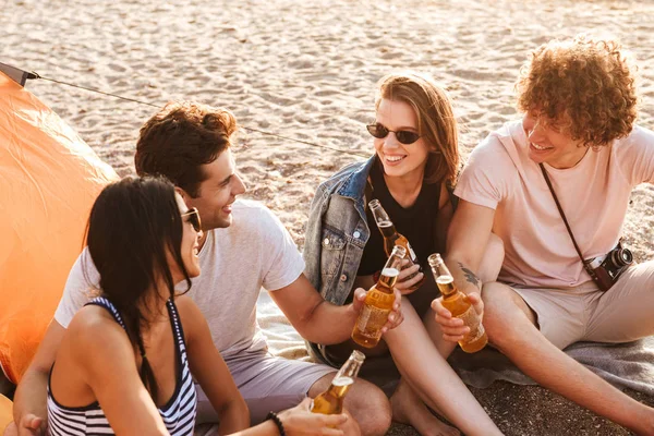 ビールを飲みながら座っているビーチの屋外友達の幸せグループの写真 — ストック写真