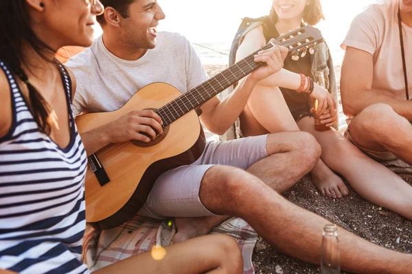 楽しく陽気な若い友人のグループ ビーチでビールを飲み キャンプしながらギターを弾く時間を一緒に — ストック写真