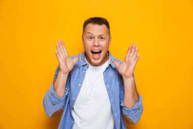 Neşeli bir orta yaşlı adam başarı sarı arka plan üzerinde izole kutlama portresi