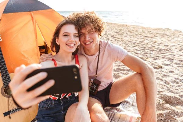 Felice Giovane Coppia Seduta Insieme Spiaggia Campeggio Prendendo Selfie — Foto Stock