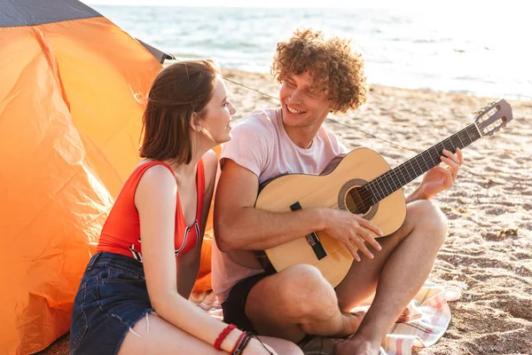 Fröhliches Junges Paar Sitzt Zusammen Strand Zeltet Spielt Gitarre — Stockfoto