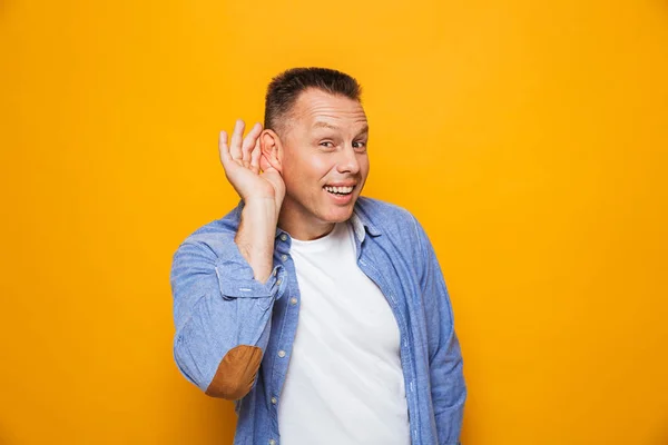 Portrait Happy Middle Aged Man Trying Hear Rumor Isolated Yellow — Stock Photo, Image