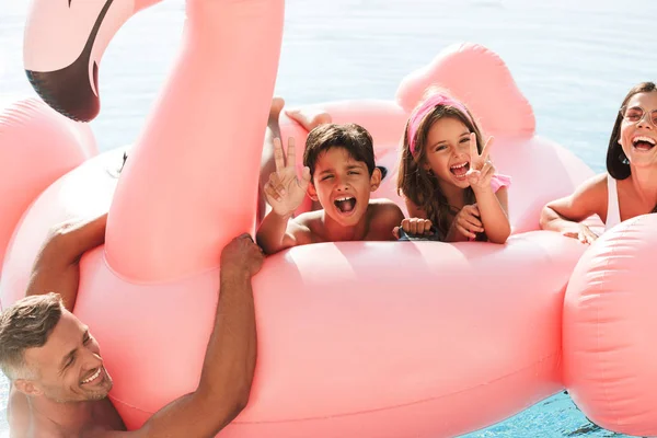 Retrato Crianças Pais Alegres Nadando Piscina Com Anel Borracha Rosa — Fotografia de Stock