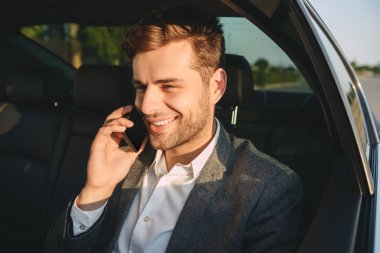 Başarılı adam 30'lu Smartphone'da geri iş sınıfı arabaya otururken klasik uymak portresi
