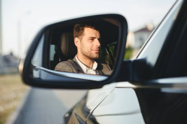 Mutlu yakışıklı genç iş adamı sürücü arabasında yol yan dikiz aynası için arıyorsunuz