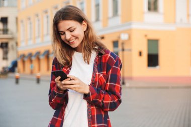 Cep telefonu kullaranarak Park'ta yürüyordunuz genç güzel kadın öğrenci görüntüsünü.