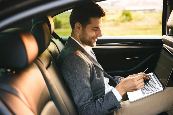 Lächelnder Geschäftsmann Mit Plastikkreditkarte Während Mit Laptop Heck Eines Autos — Stockfoto