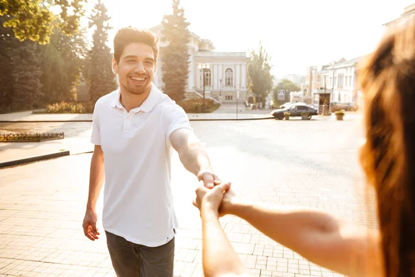 幸せな若いかわいい愛するカップル野外を歩いているお互いの手をつないでのイメージ — ストック写真