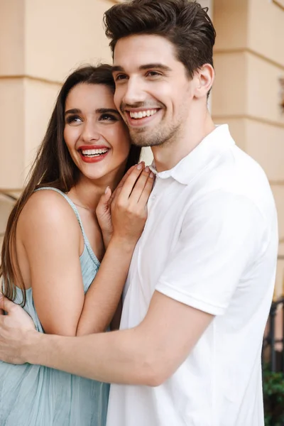 Lächelndes Junges Paar Das Sich Der Stadtstraße Umarmt Wegschaut — Stockfoto