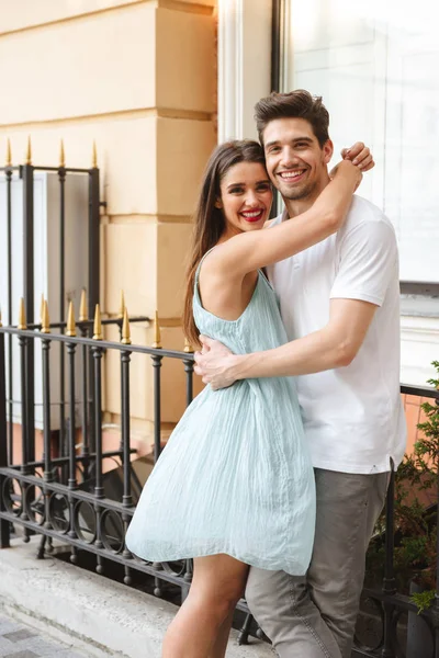 快乐的年轻夫妇拥抱在城市街道上 看着相机 — 图库照片