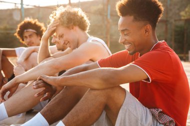 Grup Genç heyecanlı spor yere, dinlenme çok ırklı erkekler basketbol oyuncu bahsediyoruz