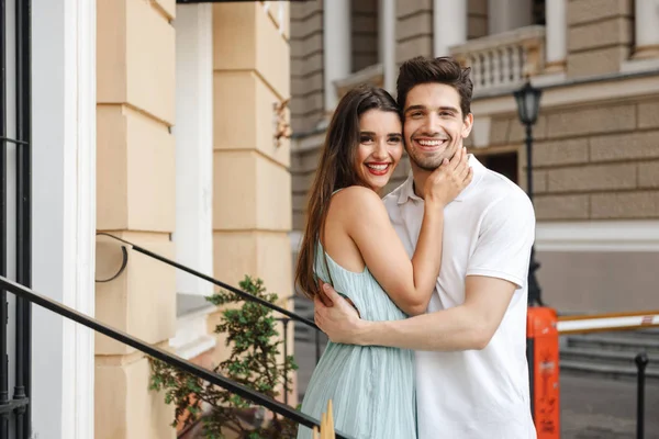 Sonriente Pareja Joven Abrazándose Calle Ciudad Mirando Cámara —  Fotos de Stock