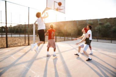 Basketbol oynarken spor yere neşeli çok ırklı gençler basketbol oyuncu grubu