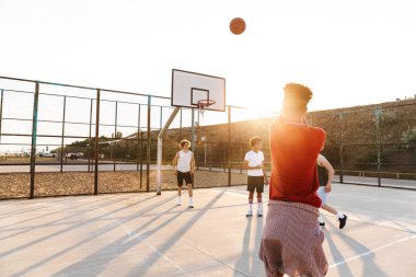 Basketbol spor yere oynarken çok ırklı gençler basketbol oyuncu grubu