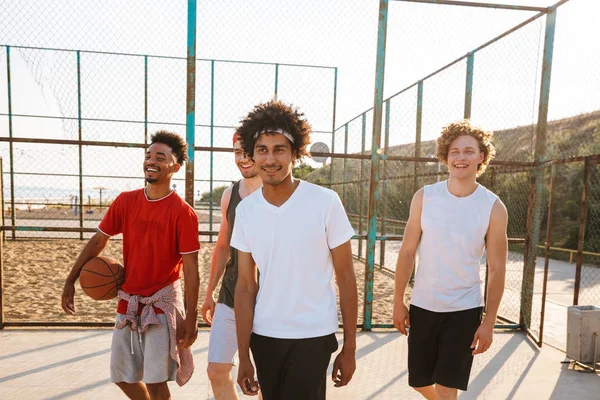 在夏季阳光明媚的日子里 白人和美国男子篮球运动员站在操场室外的形象 — 图库照片