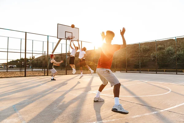 Group of young multiethnic men basketball players playing basketball at the sport ground