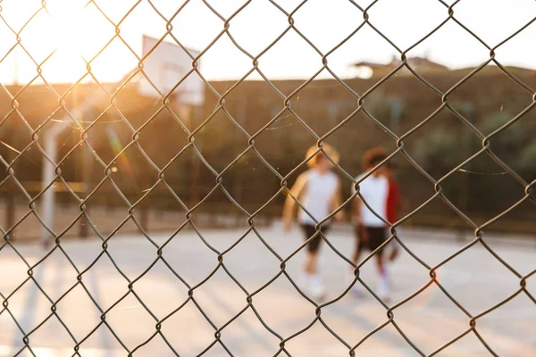 Zemin, spor çit odaklanmak basketbol oynayan neşeli çok ırklı gençler basketbol oyuncu grubu