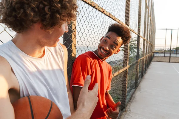 Dua Pemuda Bahagia Pemain Basket Multietnis Berdiri Lapangan Olahraga Berbicara — Stok Foto
