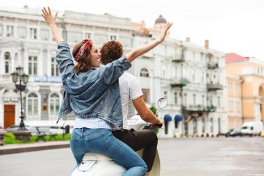 Görünüm portre mutlu bir genç çiftin birlikte şehrin sokak, bir motosiklet sürme geri