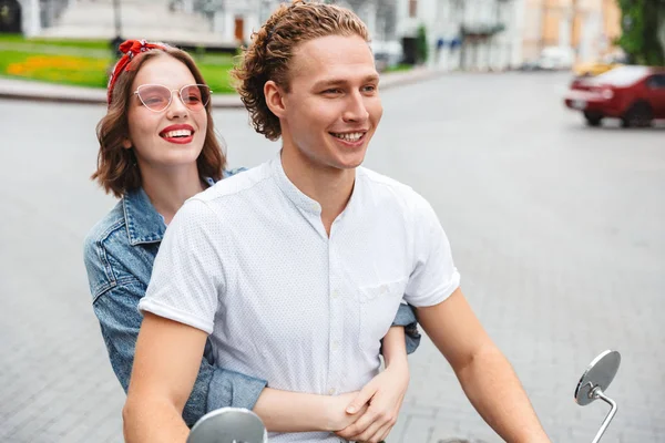 Portre pozitif bir genç çiftin şehir sokak birlikte bir motosiklet sürme